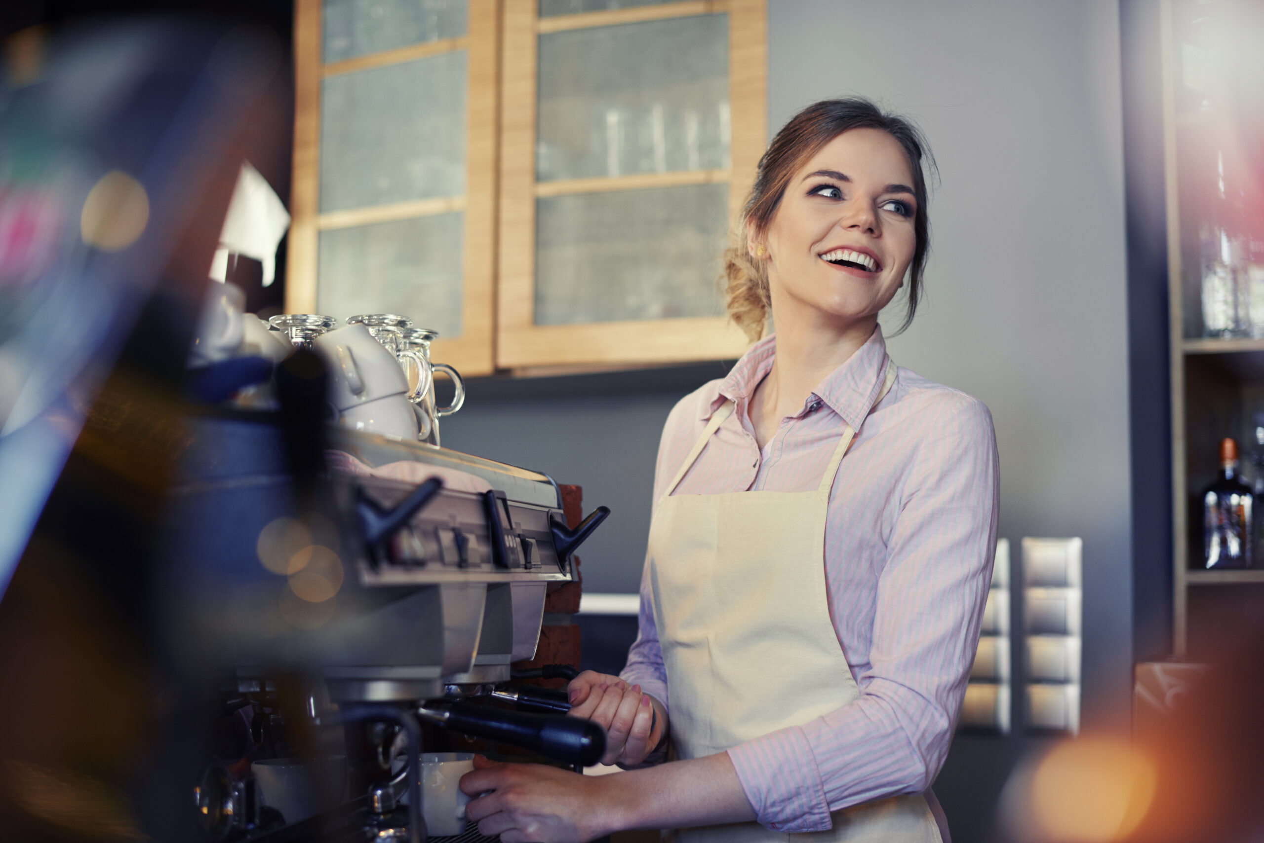 Young female barista using coffee maker NZSE