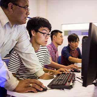 Tutor helping young male students studying NZSE