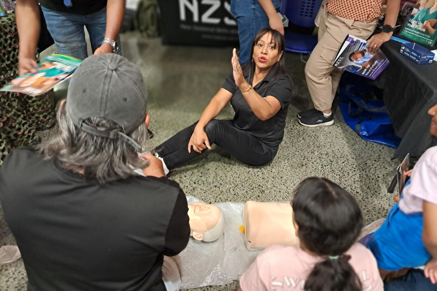 Female tutor doing a CPR demonstration at Careers expo NZSE